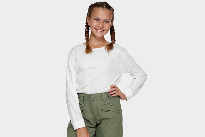 Girl in white top and green pants.