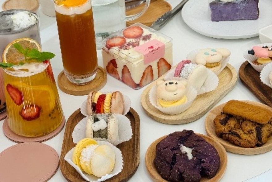 An array of small decorative cakes and long fruity drinks. 