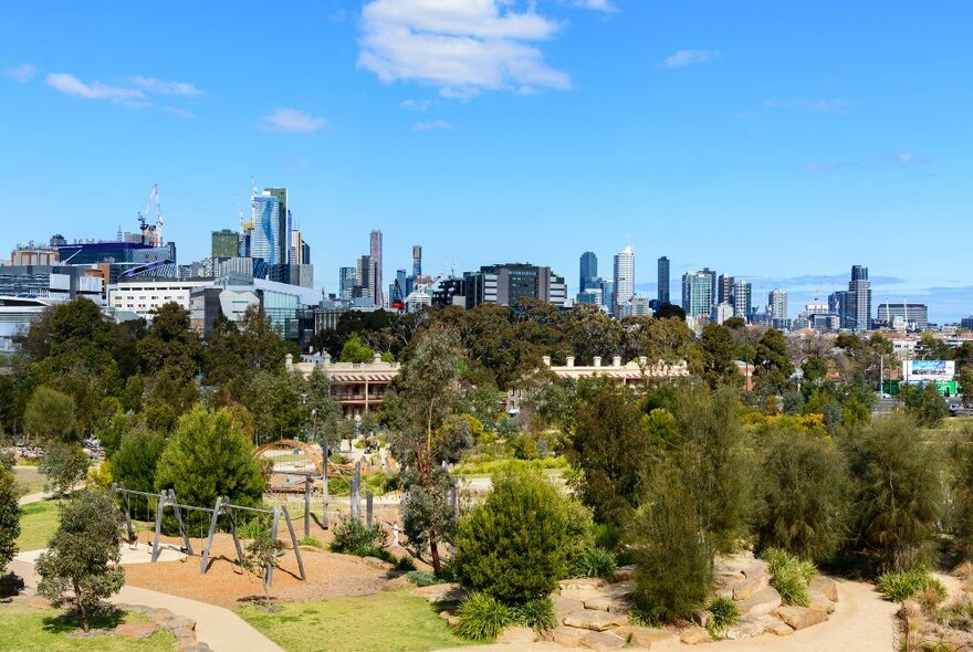 A park with a playground and the city skyline in the background