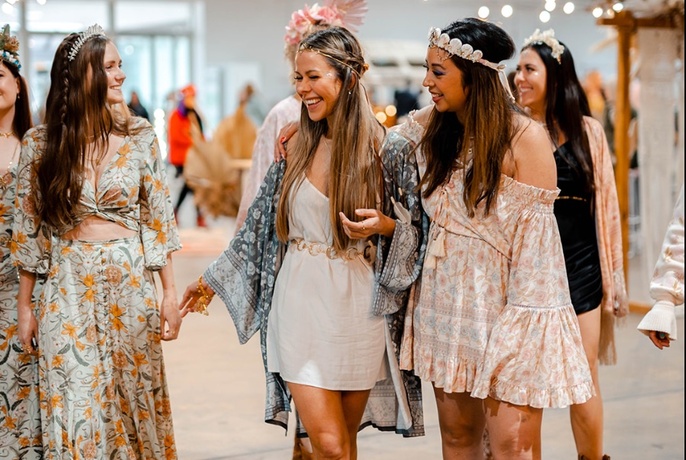 Group of smiling women wearing bohemian inspired clothing. 
