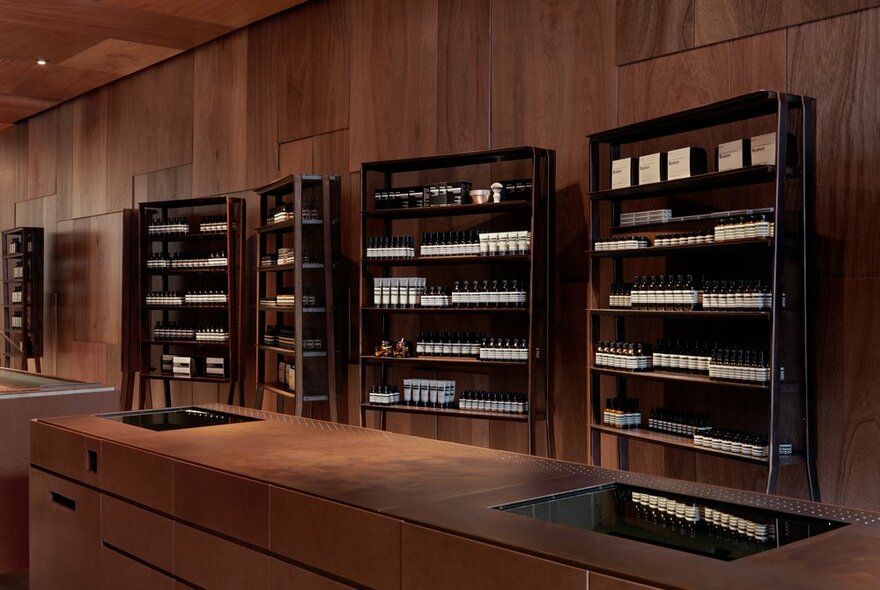 Aesop products on small shelves in a timber shop. 