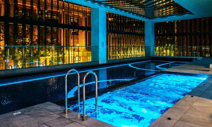A swimming pool at night lit up in blue lights
