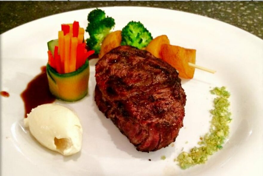 Steak and veggies artistically arranged on a plate.