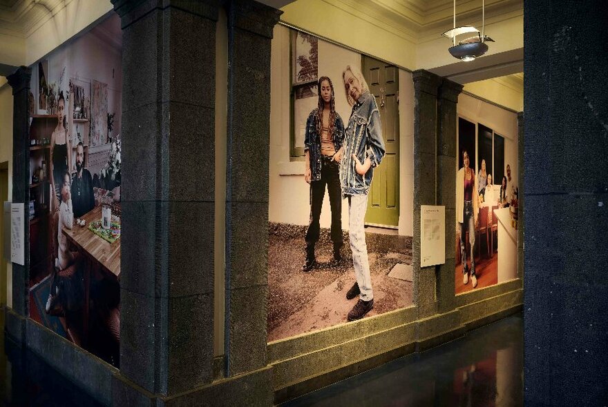 The corner of a corridor with large photographic portraits on the wall.