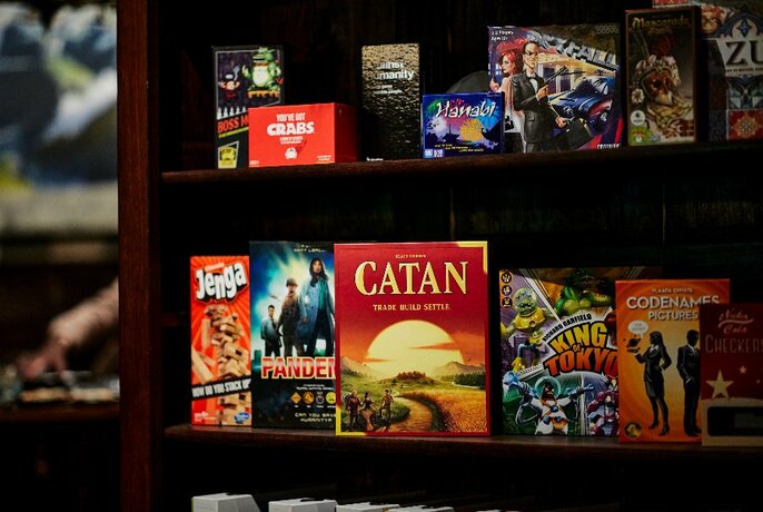 A shelf full of different board games. 