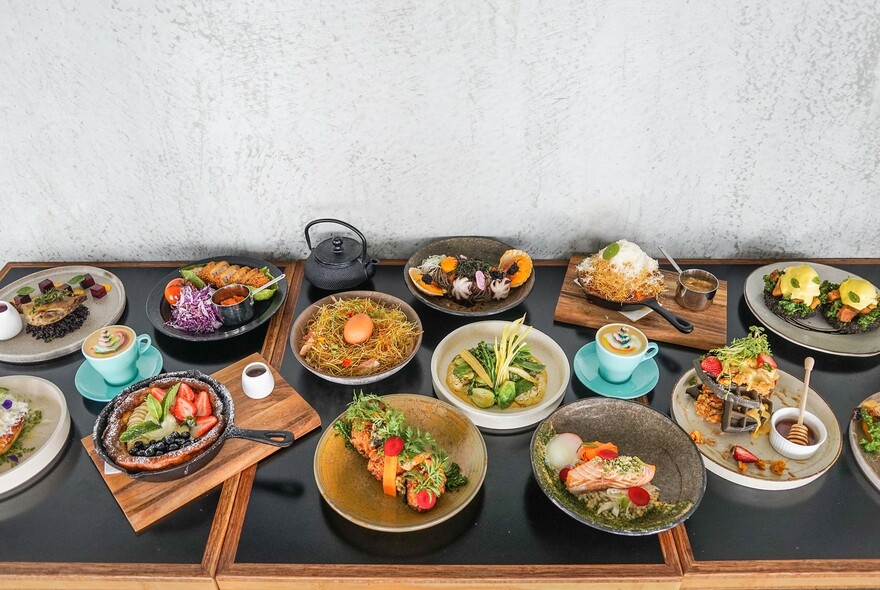 An array of savoury dishes on a table with coffee cups.