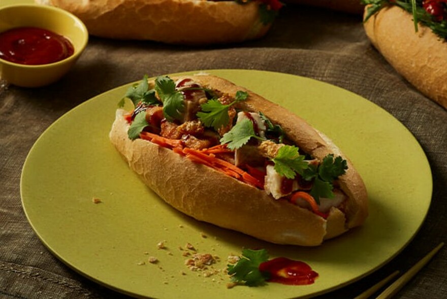 A banh mi on a green plate.