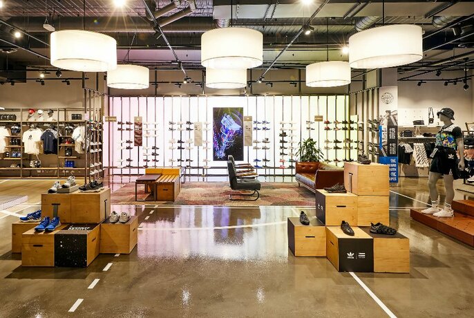 Interior of the Adidas store with clothing and a wall of shoes