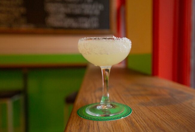 A margarita cocktail with a salted rim in a bar.