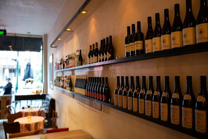 A bar with bottles of wine lining the walls.