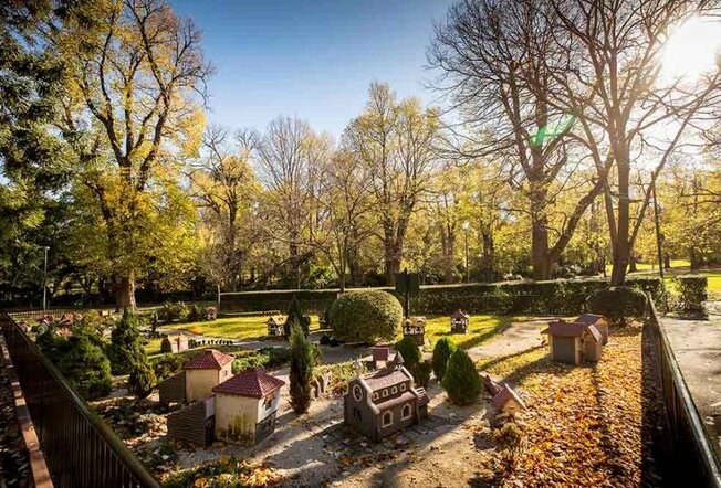 Small-scale model of old English Tudor houses, trees and roads in a public garden.