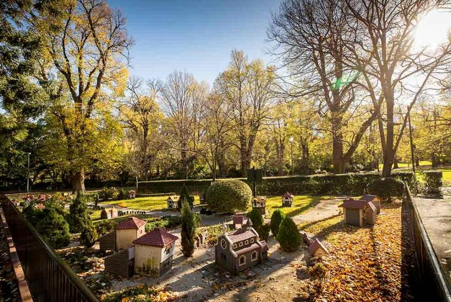 Small-scale model of old English Tudor houses, trees and roads in a public garden.