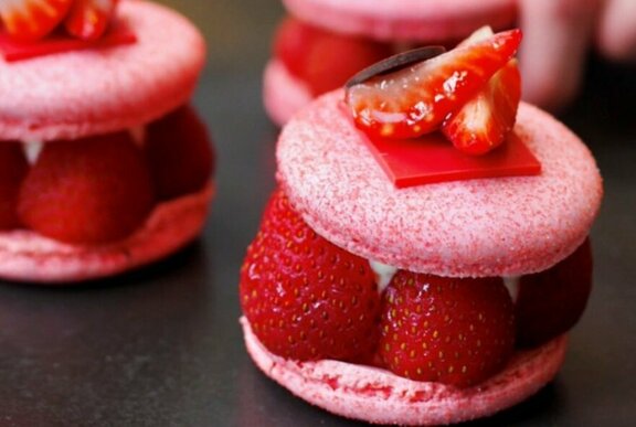 Strawberry macaron dessert sandwich with fresh strawberries and cream.