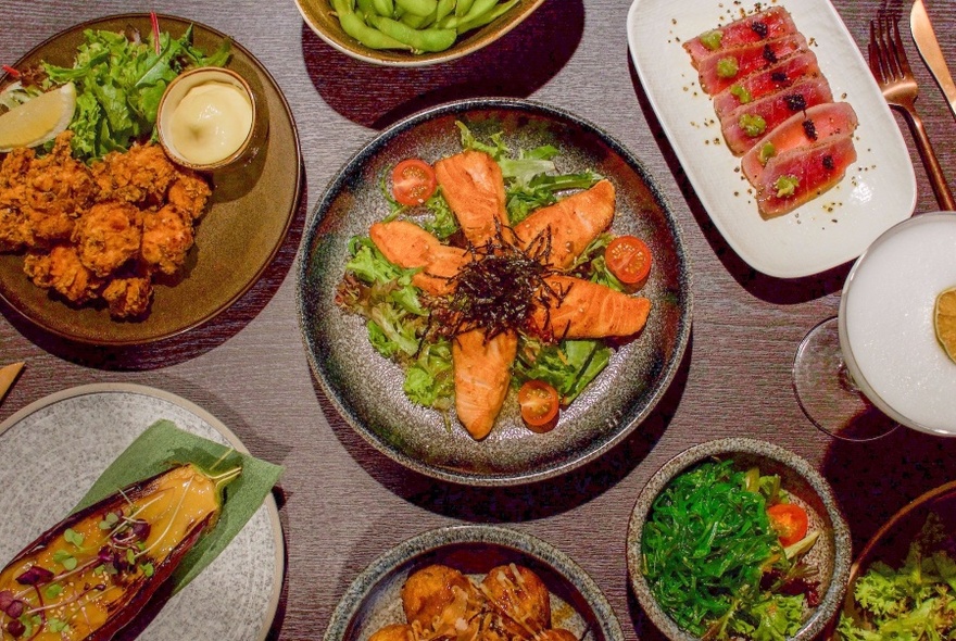 Overhead view of Asian dishes displayed on a wooden table.