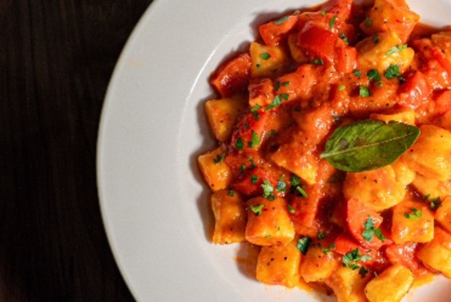 A dish of gnocchi with tomato sauce.