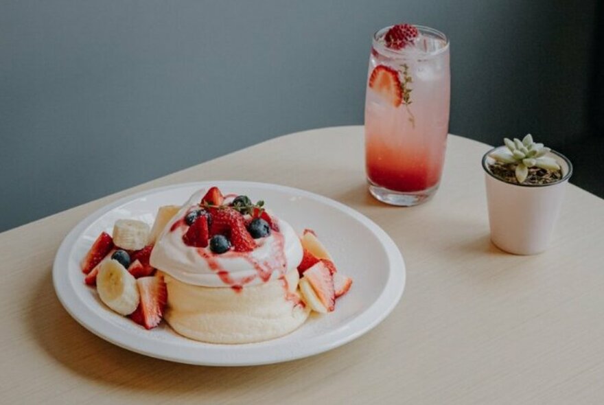 Dessert souffle pancake served with fruit and a drink.