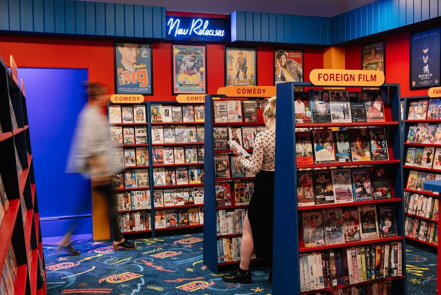 Two people are looking at a replica of a retro video shop