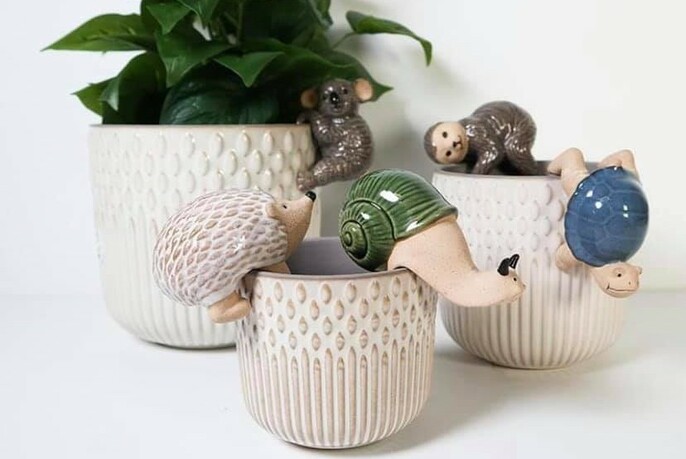 Three ceramic pots, adorned with ceramic animals.