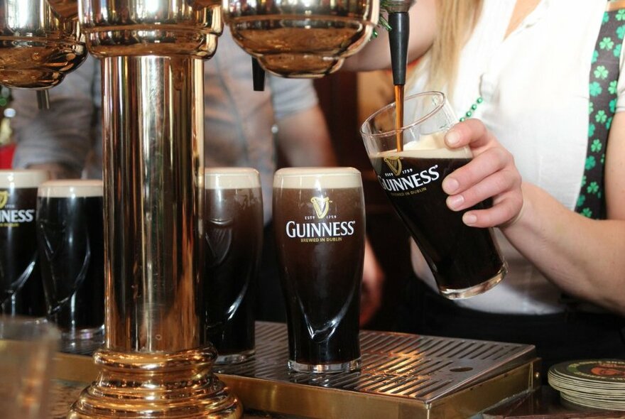 Pints of Guinness being poured.