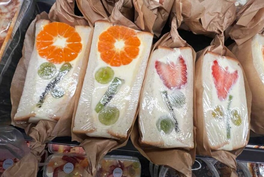 A row of dessert sandwiches with fruit cut in them to look like flowers