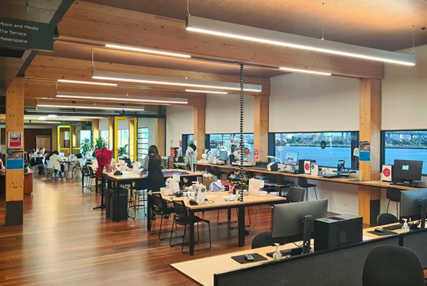 Interior work spaces with tables and chairs, at Library at The Dock.