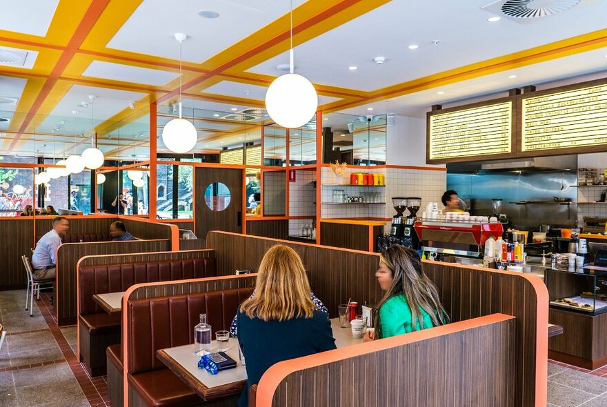 Two friends are sitting in an American-style diner