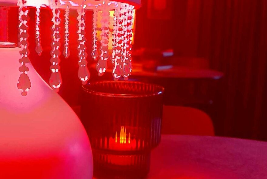Red-lit lamp with crystal drops and red candle holder.