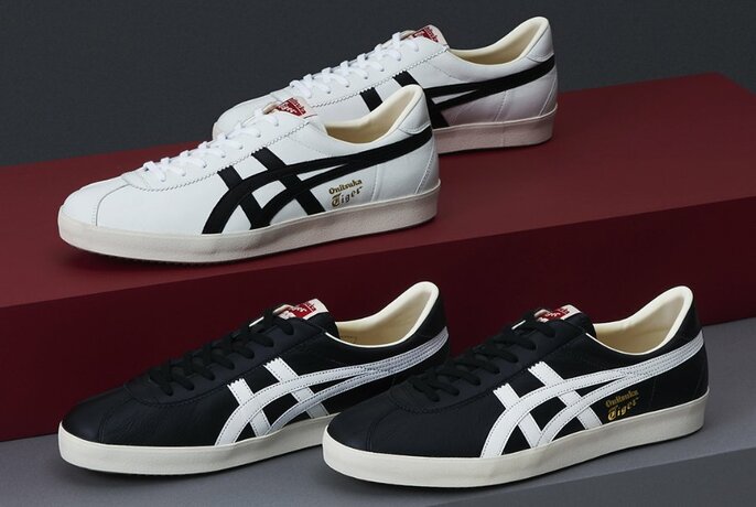 Two pairs of Onitsuka Tiger shoes – one white with black stripes, the other black with white stripes.