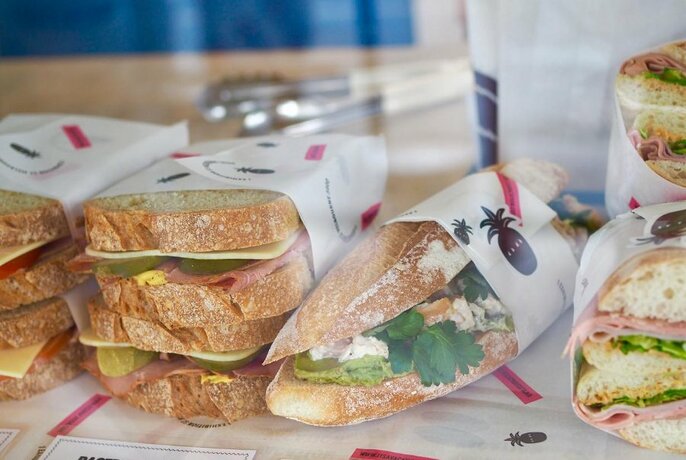 Selection of sandwiches, wrapped in paper.
