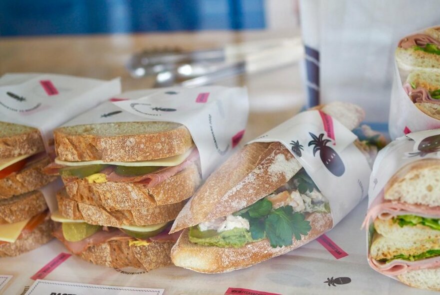 Selection of sandwiches, wrapped in paper.
