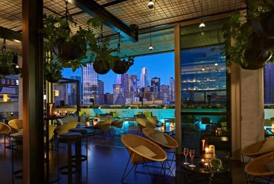 Rooftop bar setting at night looking out to cityscape.