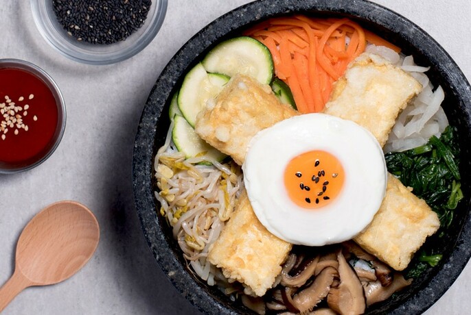 Bibimbap bowl of tofu and vegetables with egg.
