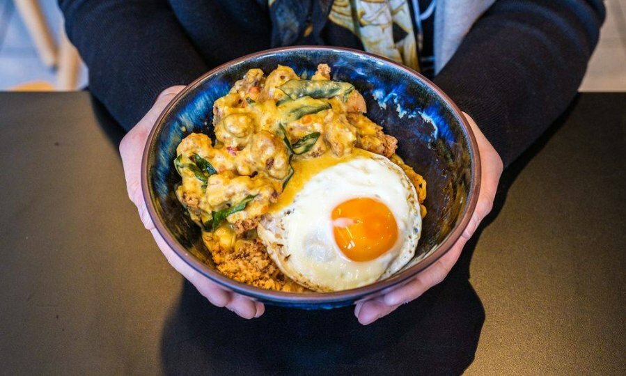 A bowl of fried chicken with rice and a fried egg