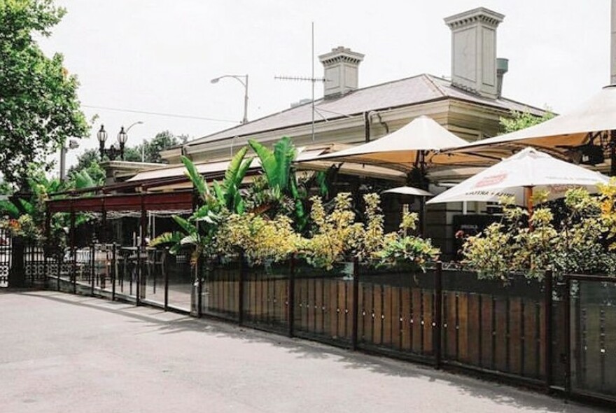 Mint Bar outdoor terrace and garden, with umbrellas and heritage building rooftop.