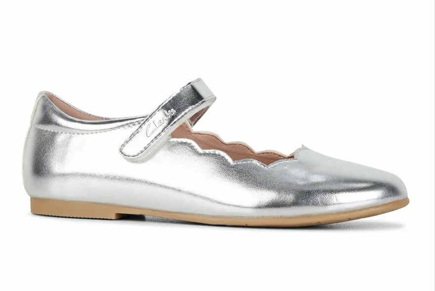 Mary Jane-style child's shoe in silver leather with scalloped edge.