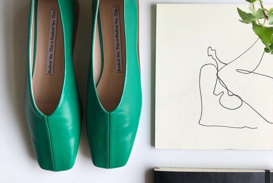 Pair of emerald green women's ballet-style shoes.