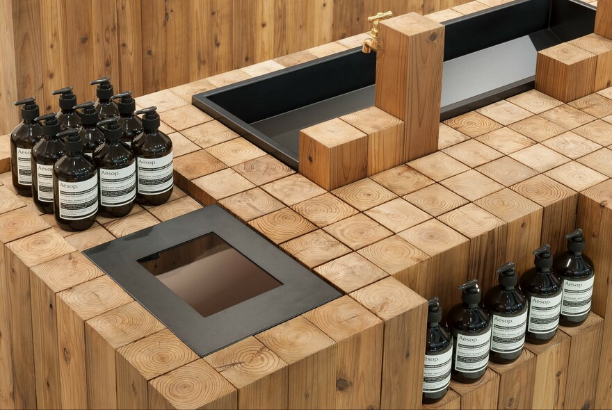 Wooden countertop at Aesop Emporium featuring a range of products.