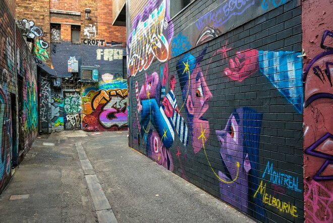 Colourful street art in Croft Alley, featuring two geometric faces in the foreground.