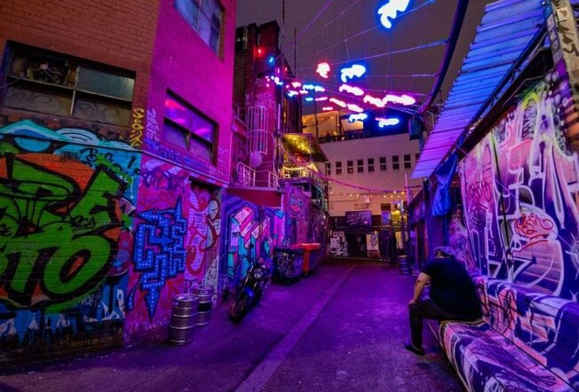 A laneway with neon lights strung across it