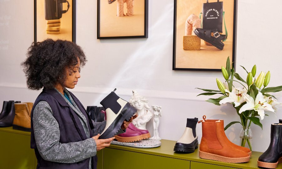 A woman is looking at a boot in a shoe store
