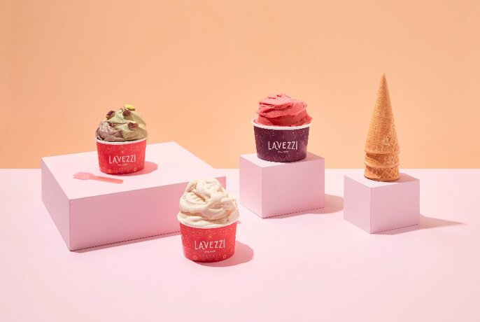 Four gelati arranged decoratively on pink boxes.