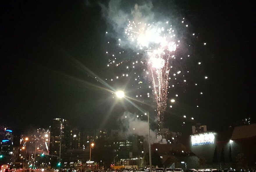 White fireworks exploding on the city skyline.