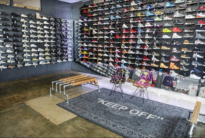 Shop interior with walls of sneakers on display.