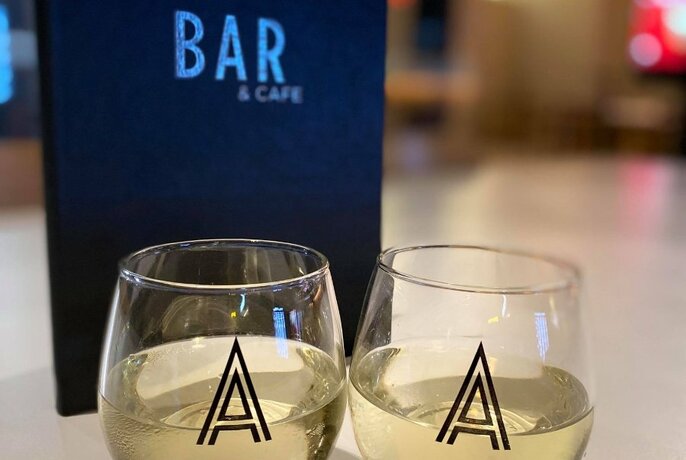 Two glasses of white wine in front of a bar menu 