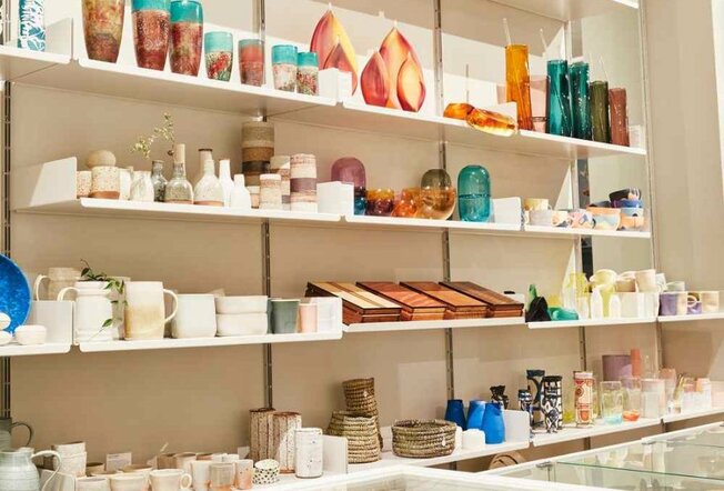 A shelf filled with craft and crockery items.