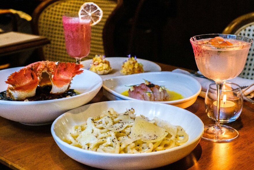 Plates of pasta and cocktails on a table