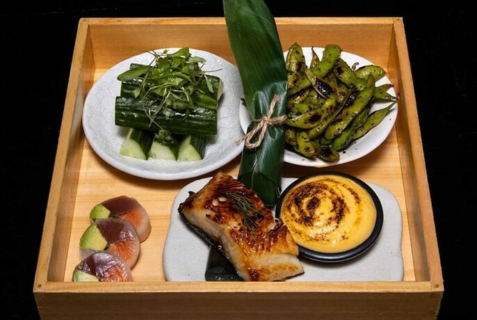 Square wooden tray of Japanese food.