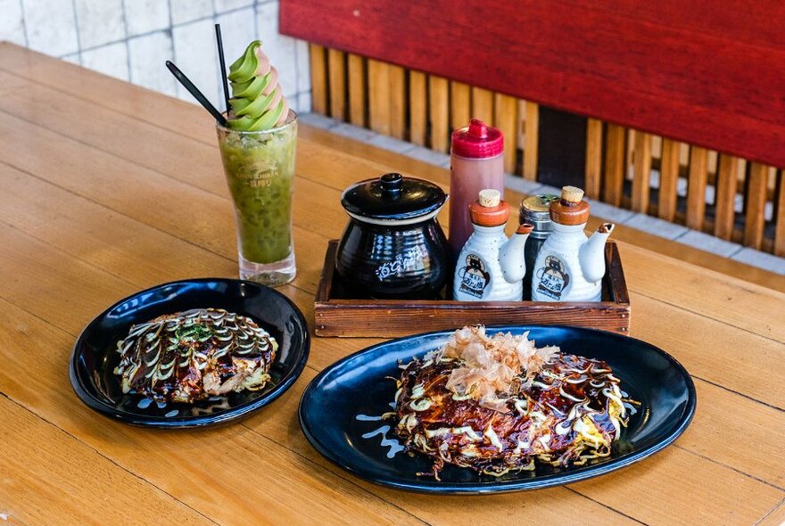 Okonomiyaki and a frozen green drink on a restaurant table. 