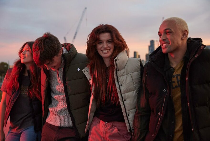 Four male and female models outdoors wearing puffer jackets.