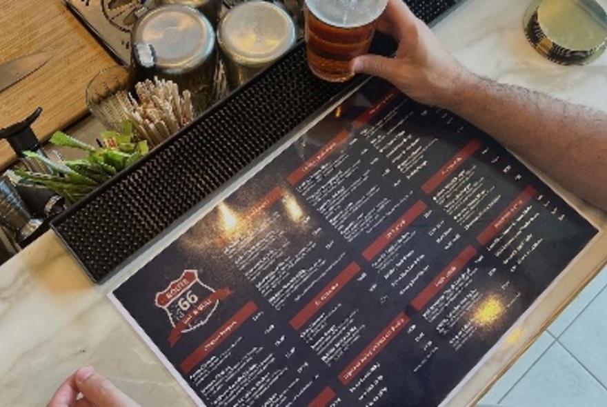 Hands holding a Route 66 menu.